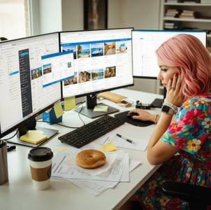 A travel agent looking overwhelmed at their desk, with multiple browser tabs open to different travel supplier portals and a confusing spreadsheet.